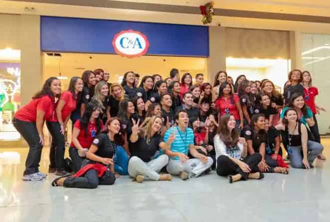 os jovens empregados em frente da loja c&a