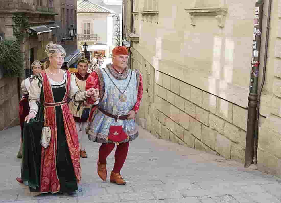 Desfile de moradores da cidade vestindo roupas medievais históricas nas ruas de San Marino